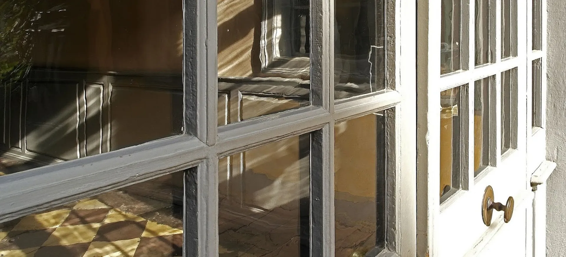 Durch die Goetheglasscheiben einer Tür fällt Licht vom Hof in den Museumsflur.